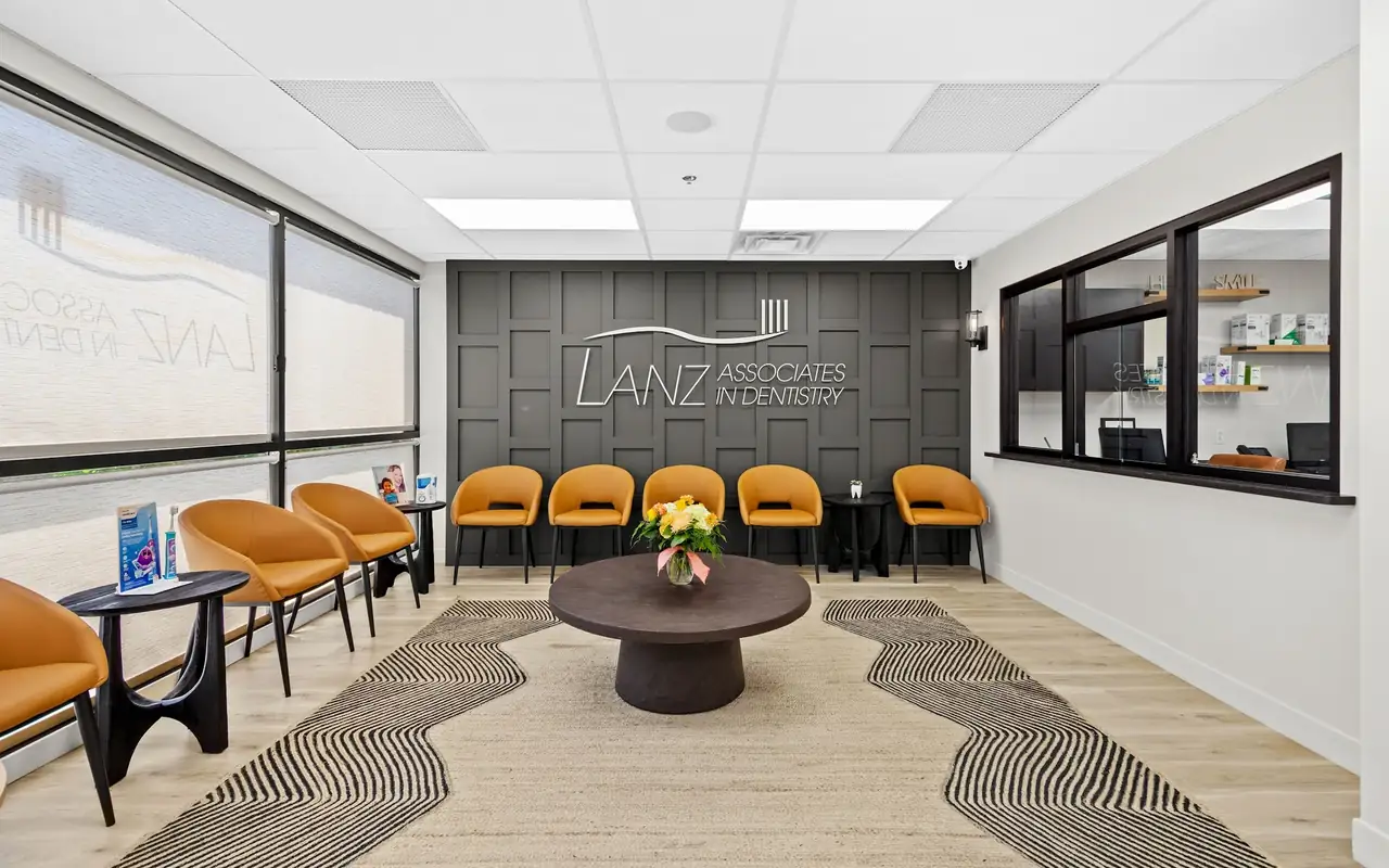 The waiting room at Lanz Associates in Dentistry in Mt. Lebanon, with the Lanz logo on the wall behind a row of chairs.